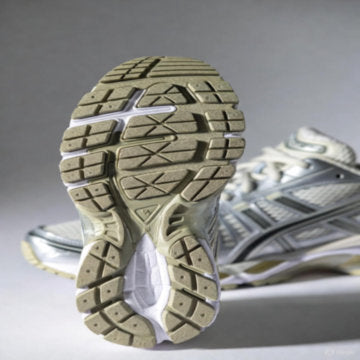 Tênis de corrida com amortecimento gel – sola em corte, pé em movimento (efeito blur).